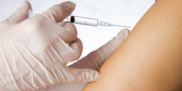 A syringe is placed in the upper arm.