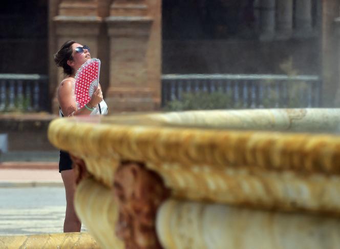 A woman tries to calm down near a fountain in Seville (Andalusia), July 10, 2021.