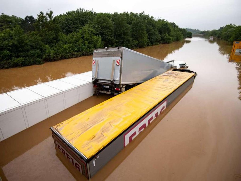 Drei Lastwagen stehen auf der überfluteten Bundesstraße 265 im tiefen Wasser und sind kaum mehr zu erkennen. Foto: Marius Becker/dpa