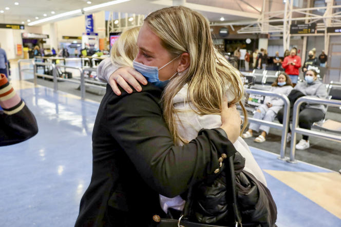 Families hug after a flight from Los Angeles arrives at Auckland International Airport as New Zealand's borders open to visa-free countries on May 2, 2022.