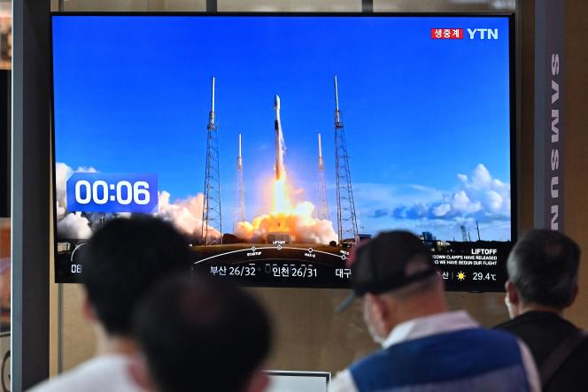 Subway users in Seoul watch, in front of a screen, the Danuri take-off bound for the moon, August 5, 2022.