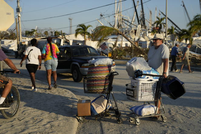 A resident waits with belongings recovered from his destroyed home after the evacuation of Estero Island in Fort Myers Beach, Florida on October 1, 2022, three days after Hurricane Ian.