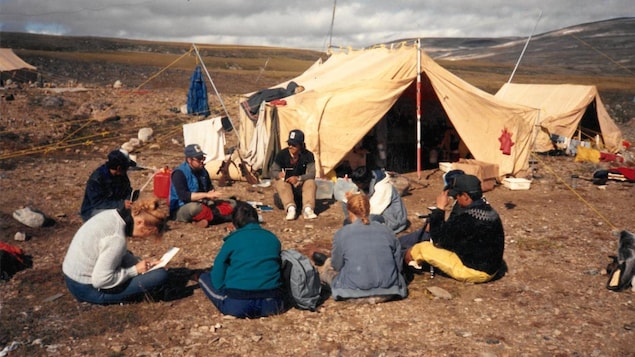 Students sit on the ground near a tent, several miles west of Iqaluit, September 1992