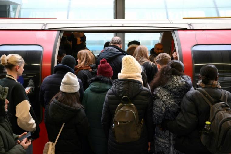 Passengers board a delayed train on December 13, 2022 in London on the first day of the railway strike (AFP/Daniel LEAL)