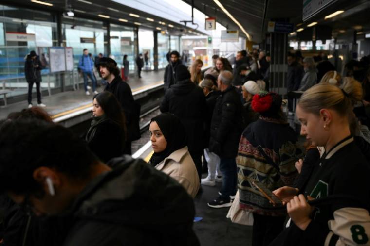 Passengers wait for a delayed train on December 13, 2022 in London on the first day of the rail strike (AFP/Daniel LEAL)